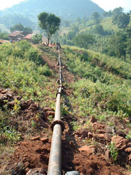 Water piped downhill for a microhydro power system in Africa