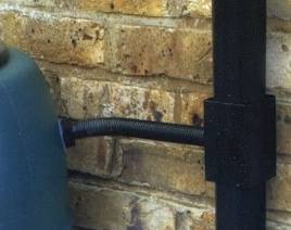A rainwater diverter fitted to a downpipe directing collected rain into a water butt