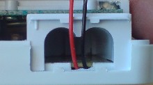 Wires emerging from the thermostat out of a groove cut out of the plastic.