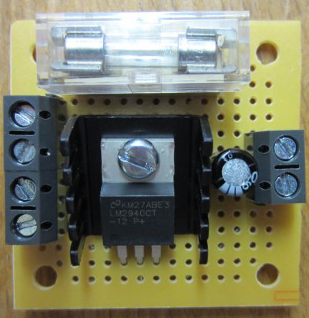 MINI 12 VOLT REGULATOR WITH FUSE AND SWITCH TERMINALS. Supply a fixed 12.0 Volt DC to your devices (up to 1 Amp output). Includes fitted 1A fuse, 2 spare fuses, and terminals for connection of a switch